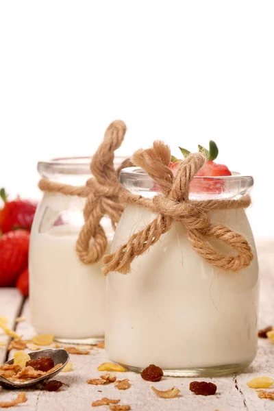 Jar dengan yogurt lezat dan stroberi dan granola muesli, atas putih di atas meja kayu — Stok Foto