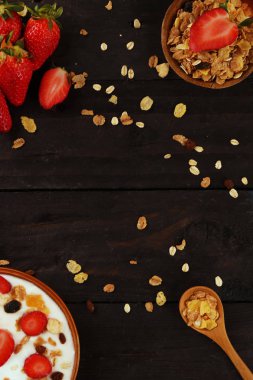 Beyaz ahşap arka planda, çilek ve granola müsli ile yoğurt kase.