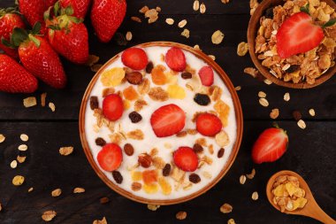 Beyaz ahşap arka planda, çilek ve granola müsli ile yoğurt kase.