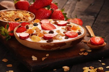 Beyaz ahşap arka planda, çilek ve granola müsli ile yoğurt kase.