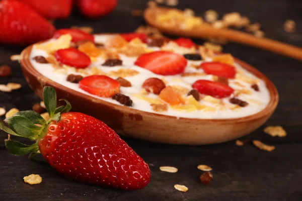 Beyaz ahşap arka planda, çilek ve granola müsli ile yoğurt kase.