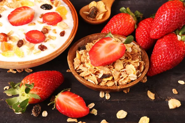 Beyaz ahşap arka planda, çilek ve granola müsli ile yoğurt kase.