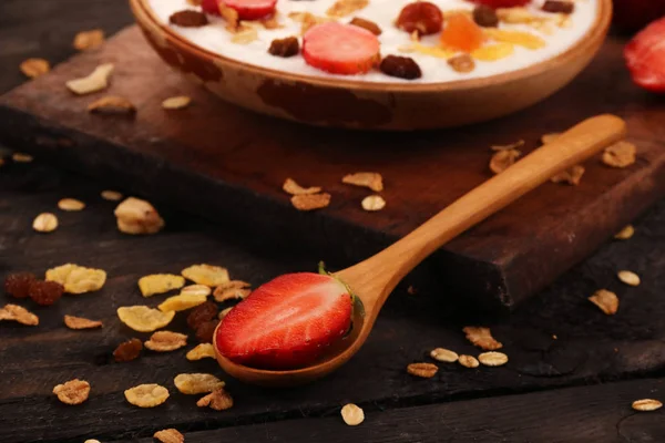Beyaz ahşap arka planda, çilek ve granola müsli ile yoğurt kase.