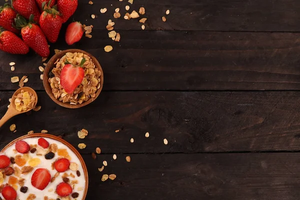 Beyaz ahşap arka planda, çilek ve granola müsli ile yoğurt kase.