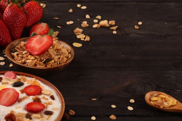 Beyaz ahşap arka planda, çilek ve granola müsli ile yoğurt kase.