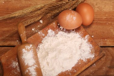 Mutfak haddeleme pin, ahşap arka planda un ile ahşap tahta, Masa üzerinde ekmek yapmak için kulakları ve yumurta.
