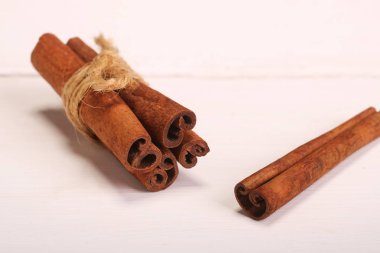 Zemin Tarçın, tarçın çubukları, ahşap beyaz arka planda Jüt kendir halat ile bağlı, seçici yumuşak odak