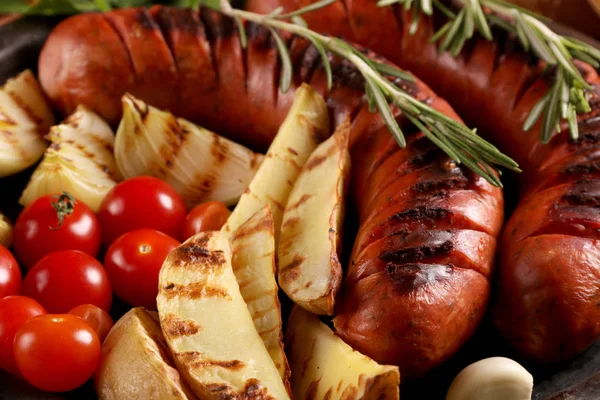 Grillwürste mit Gemüse und Gewürzen in Teller auf Holztisch. Nahaufnahme Makro-Ansicht. — Stockfoto