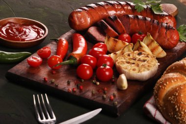 Ahşap kesme tahtası arka planda sebze, baharat ve ekmek ile ızgara sosis