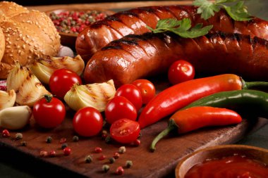 Ahşap kesme tahtası arka planda sebze, baharat ve ekmek ile ızgara sosis