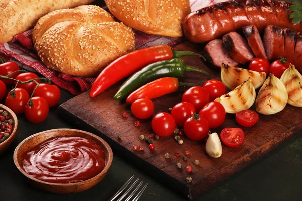 Grillwürste mit Gemüse, Gewürzen und Brot auf Holzschneidebrett Hintergrund — Stockfoto