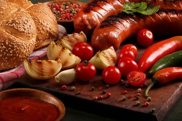 Ahşap kesme tahtası arka planda sebze, baharat ve ekmek ile ızgara sosis
