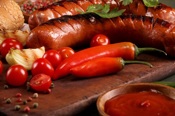 Embutidos a la parrilla con verduras, especias y pan sobre fondo de tabla de cortar de madera —  Fotos de Stock