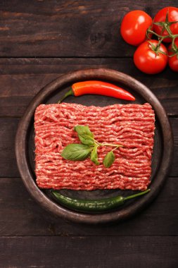 kağıt üzerinde çiğ kıyma, siyah arka plan üzerinde domates, biber, soğan, baharat ve baharat ile burger için malzemeler. Üst görünüm ve kopyalama alanı