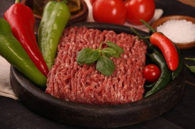 tabakta çiğ kıyma, siyah arka plan üzerinde domates, biber, soğan, baharat ve baharat ile burger için malzemeler.
