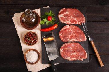 Sebze, tuz, biberiye ve baharattaş masa üzerinde pişirme ile Çiğ domuz eti biftek. Üstte görüntü.