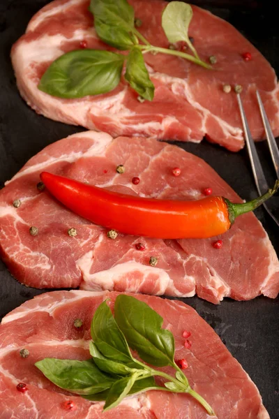 Filete crudo de carne de cerdo con verduras, sal, romero y especias que se cocinan sobre una mesa de piedra. Vista superior . — Foto de Stock