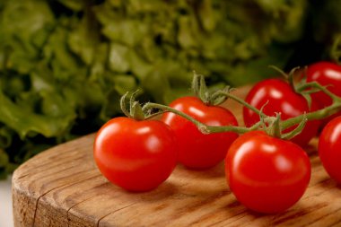 Beyaz bir masada Yeşil Marul ile kesme tahtası üzerinde kiraz domates Olgun taze Sulu organik brunch