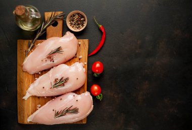 Çiğ tavuk göğsü fileto, ahşap kesme tahtası baharatlar ile pişirme için hazır. belirli bir arka plan üzerinde. kopya alanı ile Üstten Görünüm