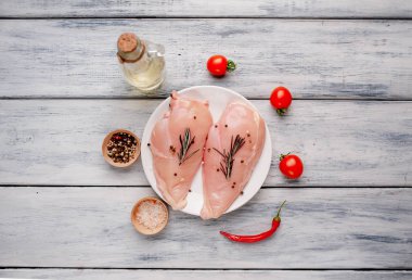 Çiğ tavuk göğsü fileto ahşap kesme tahtası baharatlar ile pişirme için hazır. ahşap bir masaya