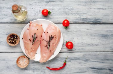 Çiğ tavuk göğsü fileto ahşap kesme tahtası baharatlar ile pişirme için hazır. ahşap bir masaya