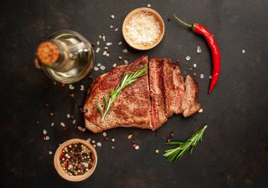 New York siyah angus sığır eti doğurmak bir beton zemin üzerine malzemelerle biftek yemek hazır. Karanlık bir taş zemin üzerine akşam yemeğine hazır yemek