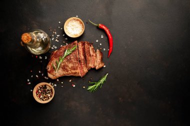New York siyah angus sığır eti doğurmak bir beton zemin üzerine malzemelerle biftek yemek hazır. Karanlık bir taş zemin üzerine akşam yemeğine hazır yemek