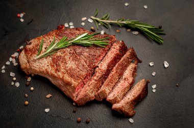 New York siyah angus sığır eti doğurmak bir beton zemin üzerine malzemelerle biftek yemek hazır. Karanlık bir taş zemin üzerine akşam yemeğine hazır yemek