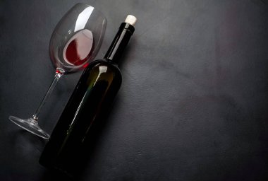 Kırmızı şarap ve taş çerçevede bir şişe şarap kadehi. Kopya alanı ile Üstten Görünüm