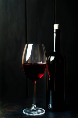 -Bir şişe şarap ve şarap karanlık bir arka plan üzerinde 