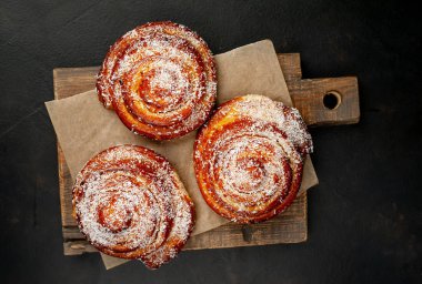 Taze ev yapımı Cinnabon ahşap doğrama tahtasında kurutulmuş Hindistan cevizi ile serpilir