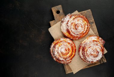 Taze ev yapımı Cinnabon ahşap doğrama tahtasında kurutulmuş Hindistan cevizi ile serpilir