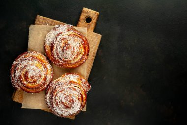 Taze ev yapımı Cinnabon ahşap doğrama tahtasında kurutulmuş Hindistan cevizi ile serpilir
