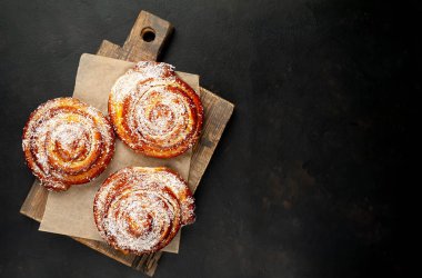 Taze ev yapımı Cinnabon ahşap doğrama tahtasında kurutulmuş Hindistan cevizi ile serpilir
