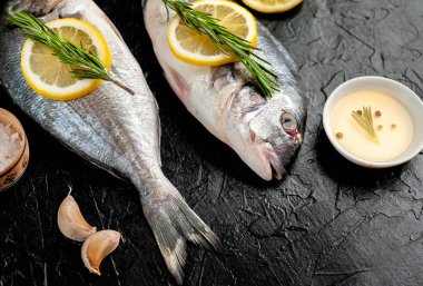 Taş arka planda limon ve biberiye dallar ile çiğ balık yakın görünümü 