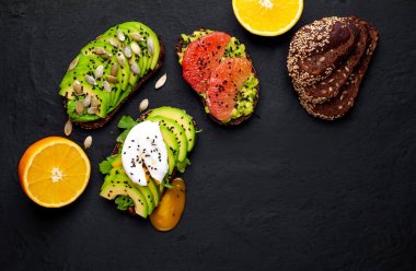 Avokado dilimleri, greyfurt, taş arka planda haşlanmış yumurta ile taze tost