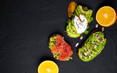 Avokado dilimleri, greyfurt, taş arka planda haşlanmış yumurta ile taze tost