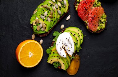 Avokado dilimleri, greyfurt, taş arka planda haşlanmış yumurta ile taze tost