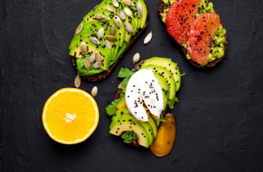 Avokado dilimleri, greyfurt, taş arka planda haşlanmış yumurta ile taze tost