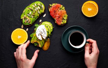 fincan kahve, koyu taş arka planda dilimlenmiş avokado, yumurta ve greyfurt ile tost ile servis