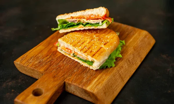 Sandwich Panini Parrilla Sobre Tabla Cortar Madera Sobre Fondo Piedra — Foto de Stock
