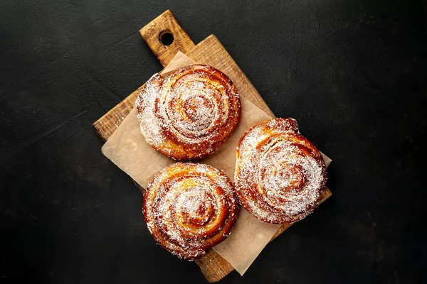 Taze ev yapımı Cinnabon ahşap doğrama tahtasında kurutulmuş Hindistan cevizi ile serpilir