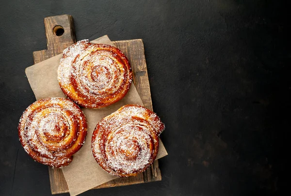 Taze ev yapımı Cinnabon ahşap doğrama tahtasında kurutulmuş Hindistan cevizi ile serpilir