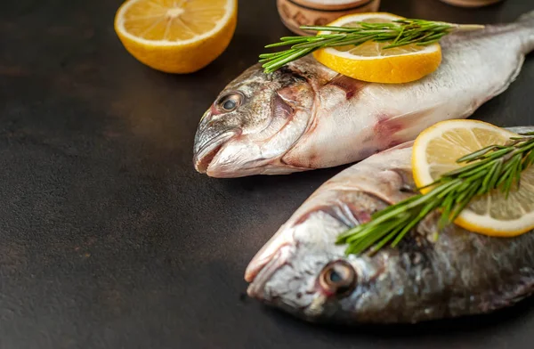 Taş arka planda limon ve biberiye dallar ile çiğ balık yakın görünümü 