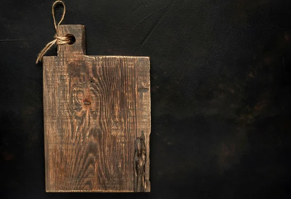 old rustic wooden board on black stone background