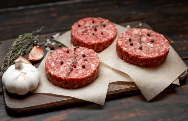 Ahşap tahta üzerinde baharatlar ile ham kıyılmış sığır Burger