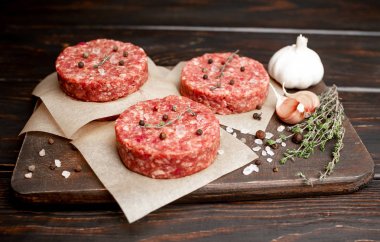 Ahşap tahta üzerinde baharatlar ile ham kıyılmış sığır Burger