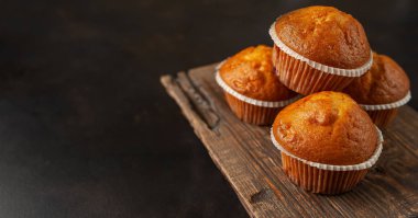 Siyah taş arka planda Ahşap Doğrama Kurulu üzerinde taze ev yapımı kekler