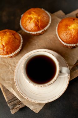 Taze pişmiş kekler ahşap tahta üzerinde bir fincan kahve ile servis