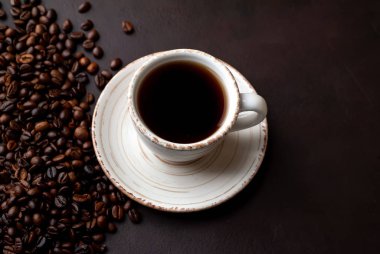 Kahve çekirdekleri ile siyah taş arka planda kahve taze fincan 